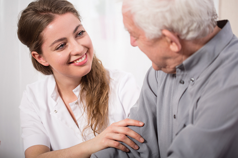 Smiling worker assisting senior man