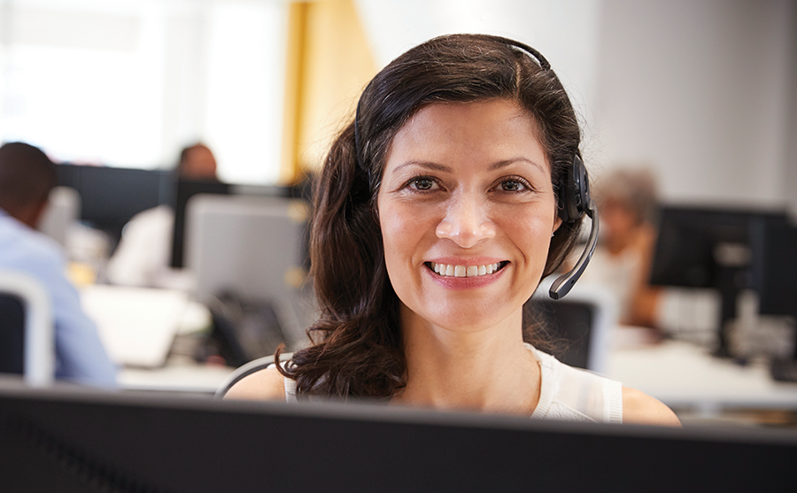 Woman smiling at the camera and working in a call centre Woman smiling at the camera and working in a call centre