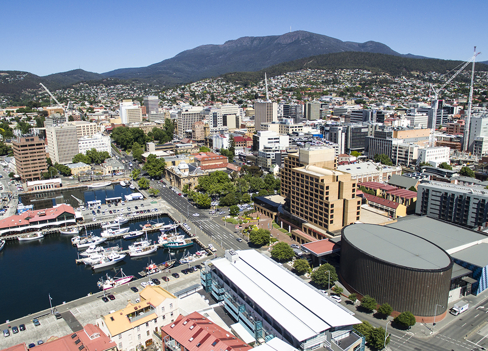 Aerial shot of Hobart featuring featuring a majestic Mount Wellington/ Kunanyi and construction cranes