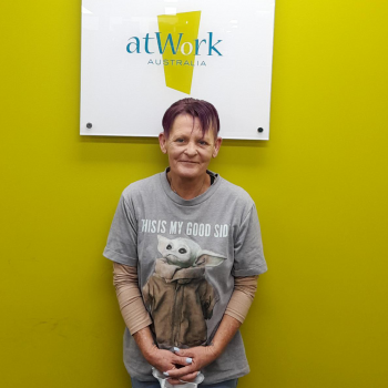 Disability Employment Services client Tanya stands proudly in the atWork Australia office in her favourite yoda shirt